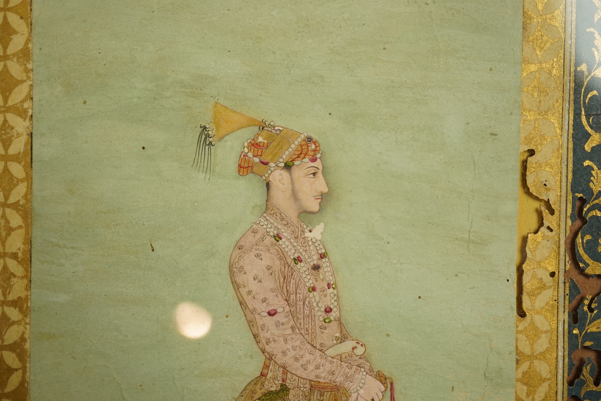 Mogul (Mughal) School , Profile Portrait of a Mogul dignitary, possibly Shah Jahan (1592-1666), full length, wearing court attire and a sword, standing in a landscape, watercolour miniature, 31cm x 20.5cm including borde
